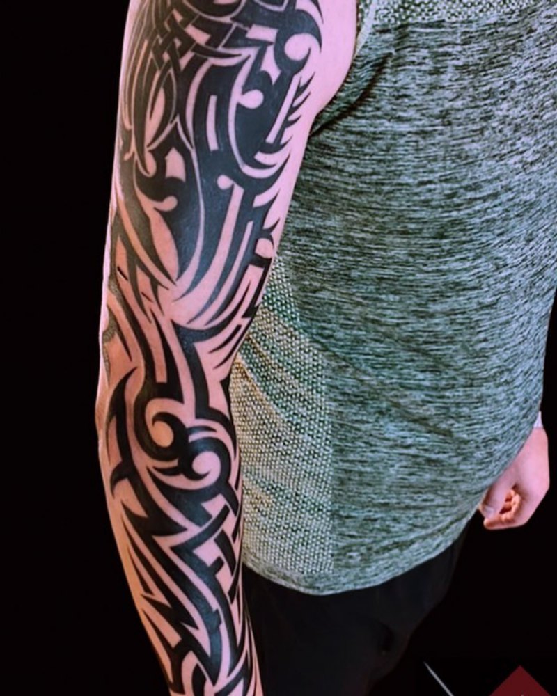 Tribal-Tattoo in durchgehendem Schwarz über den ganzen Arm