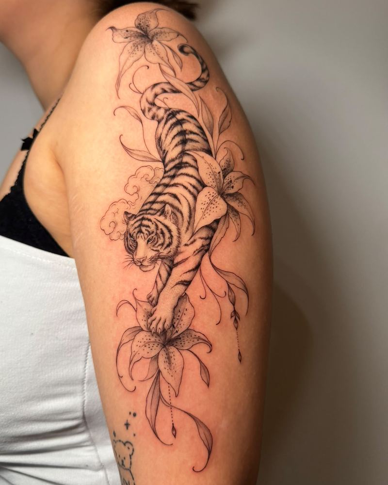 Größeres Fineline Tattoo mit Tiger und Lilien am Oberarm