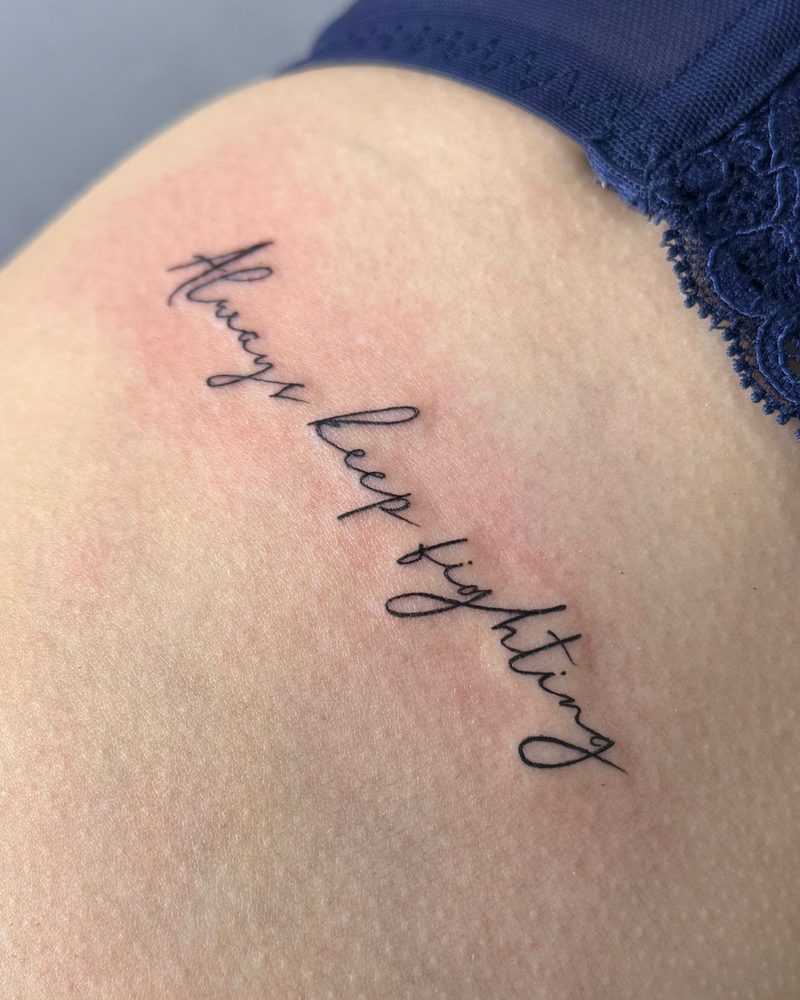 Schriftzug „Always keep fighting“ an der Hüfte