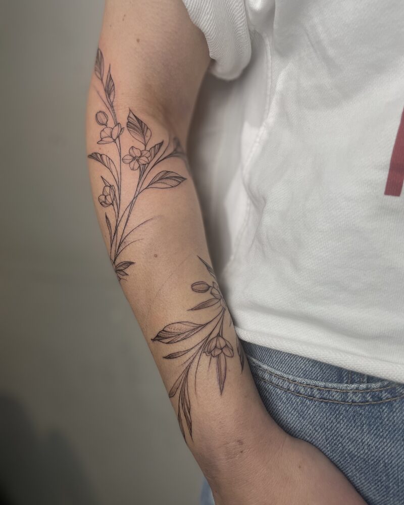 Blütenranken als Fineline Tattoo um den Unterarm