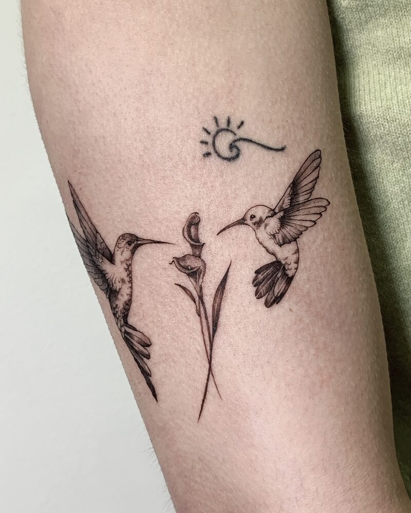 Fineline Tattoo mit zwei Kolibris und Blüte am Unterarm, gestochen bei LSD Tattoo Berlin