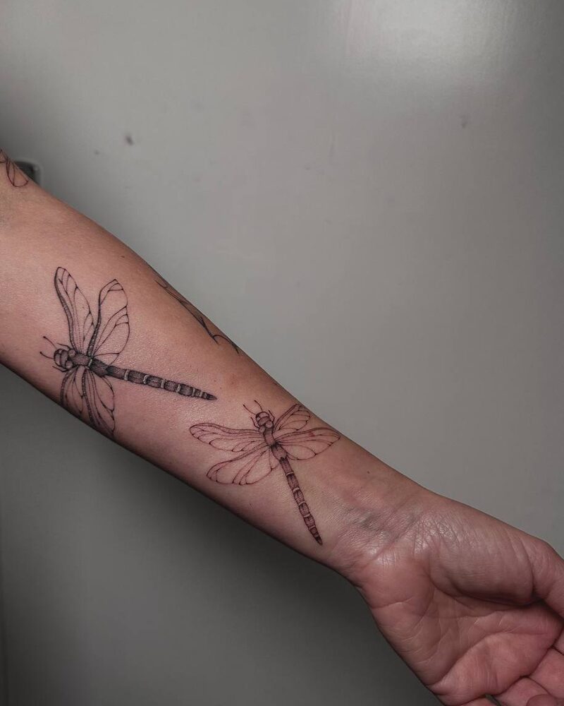 Zwei Libellen als Fineline Tattoo am Unterarm